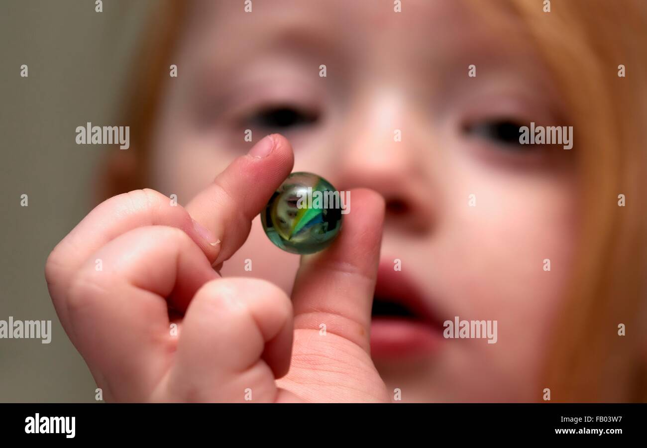 a-three-year-old-girl-holding-a-single-marble-stock-photo-alamy