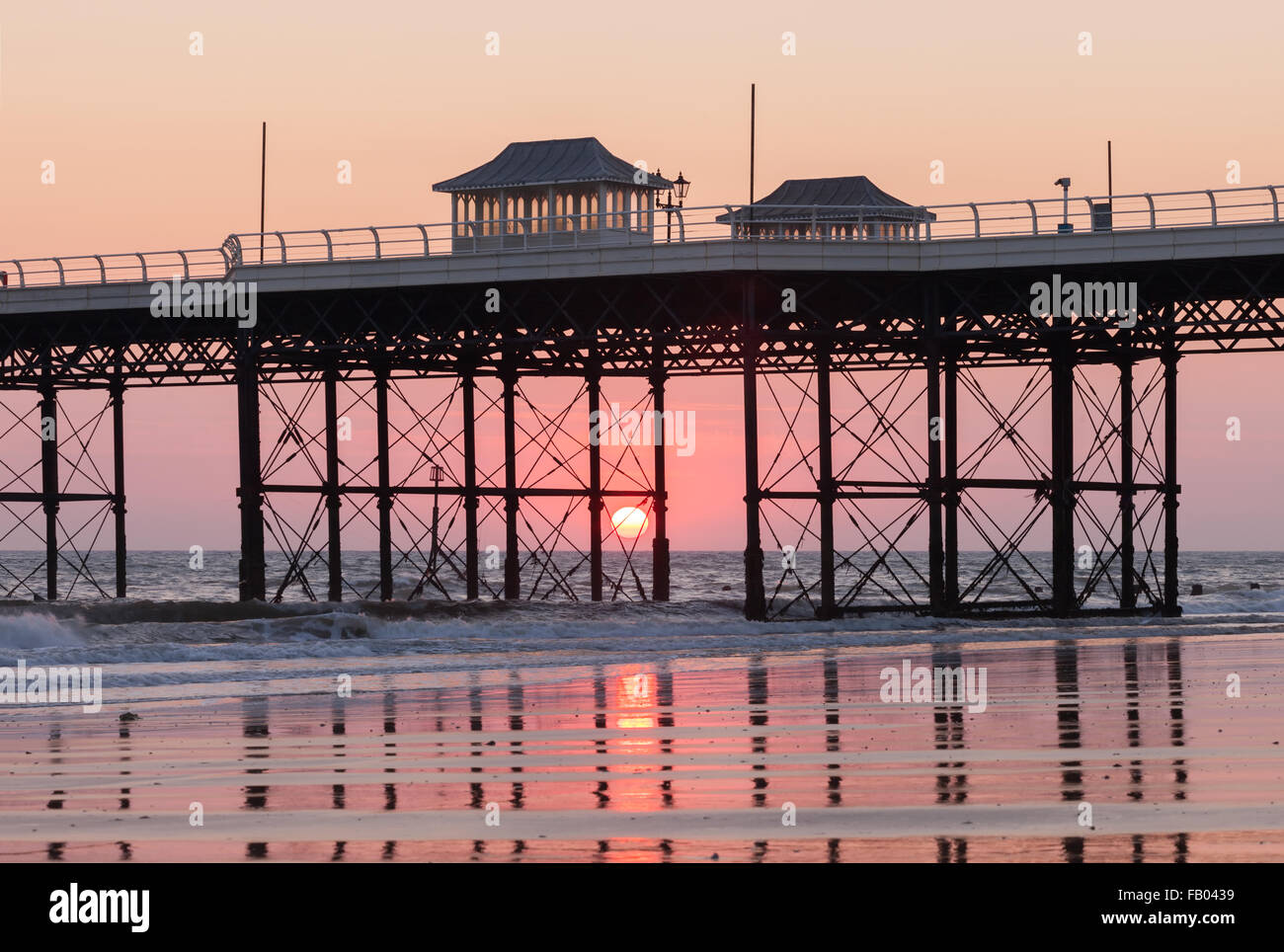 The sun rising behind Cromer Pier on the Norfolk coast, England, UK ...