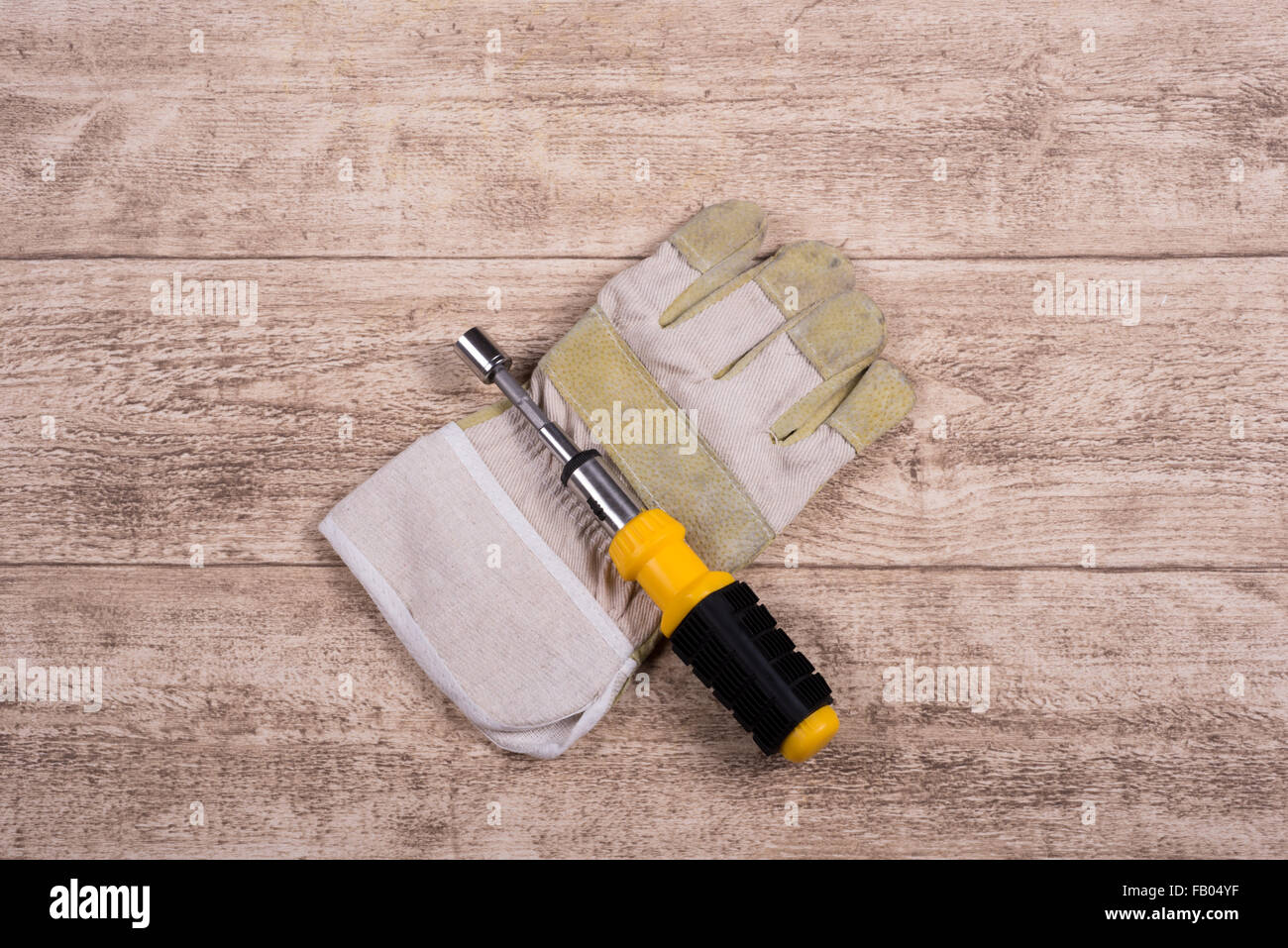 steel tool and working glove on a wooden table Stock Photo