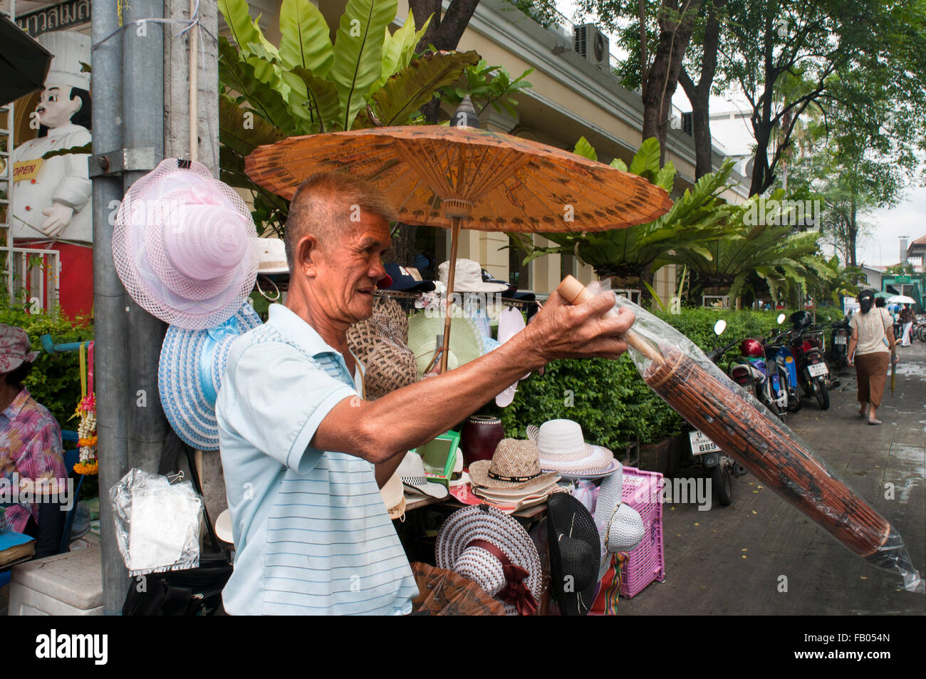 Umbrella seller. Facade of a temple, Wat Traimit, Bangkok, Thailand. Wat Traimit in Bangkok. Temple Of Golden Buddha In Chinatow Stock Photo