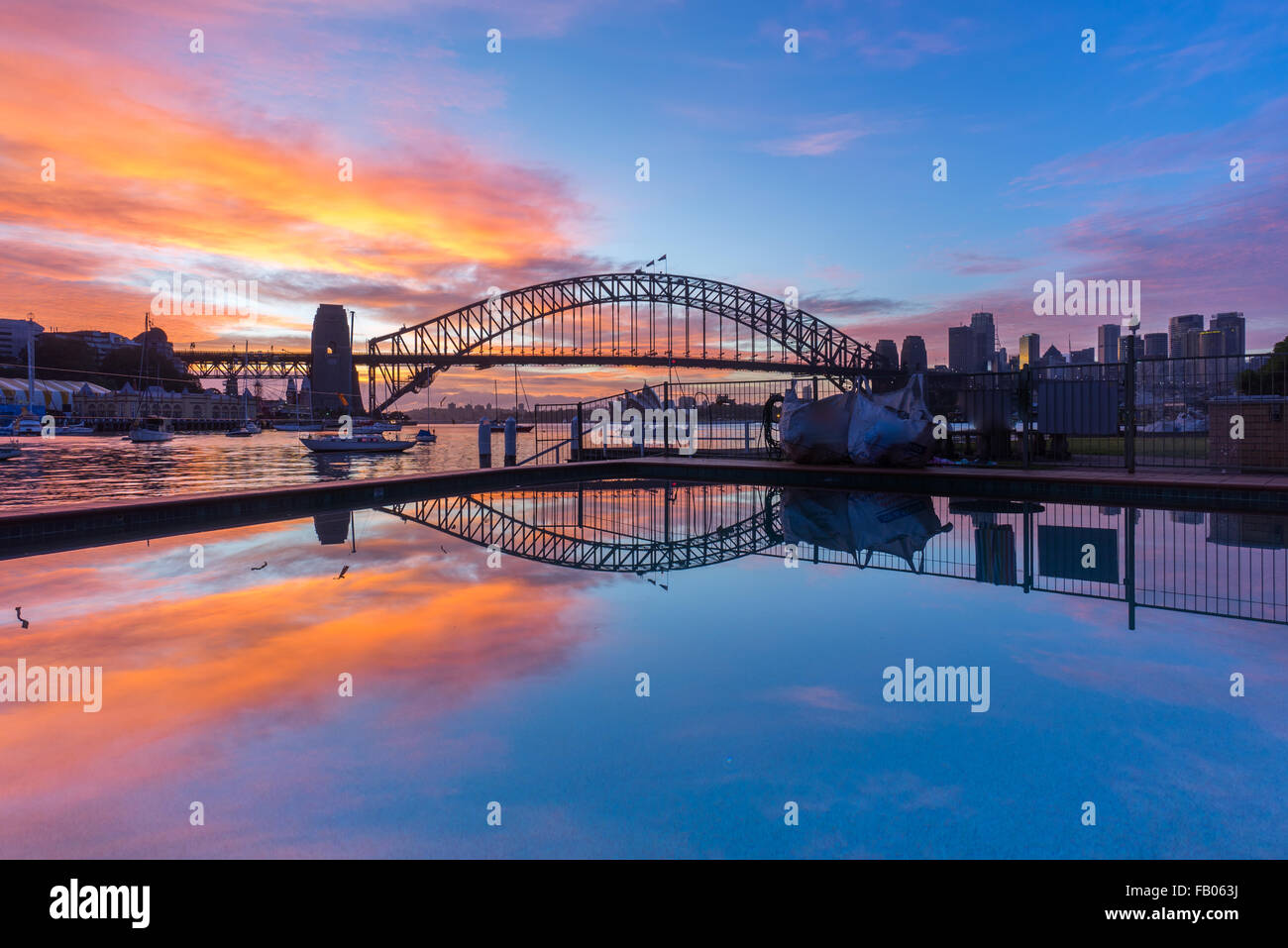 Beautiful sunrise scene at Sydney Harbour Bridge with dramatic sky colour and reflection Stock Photo
