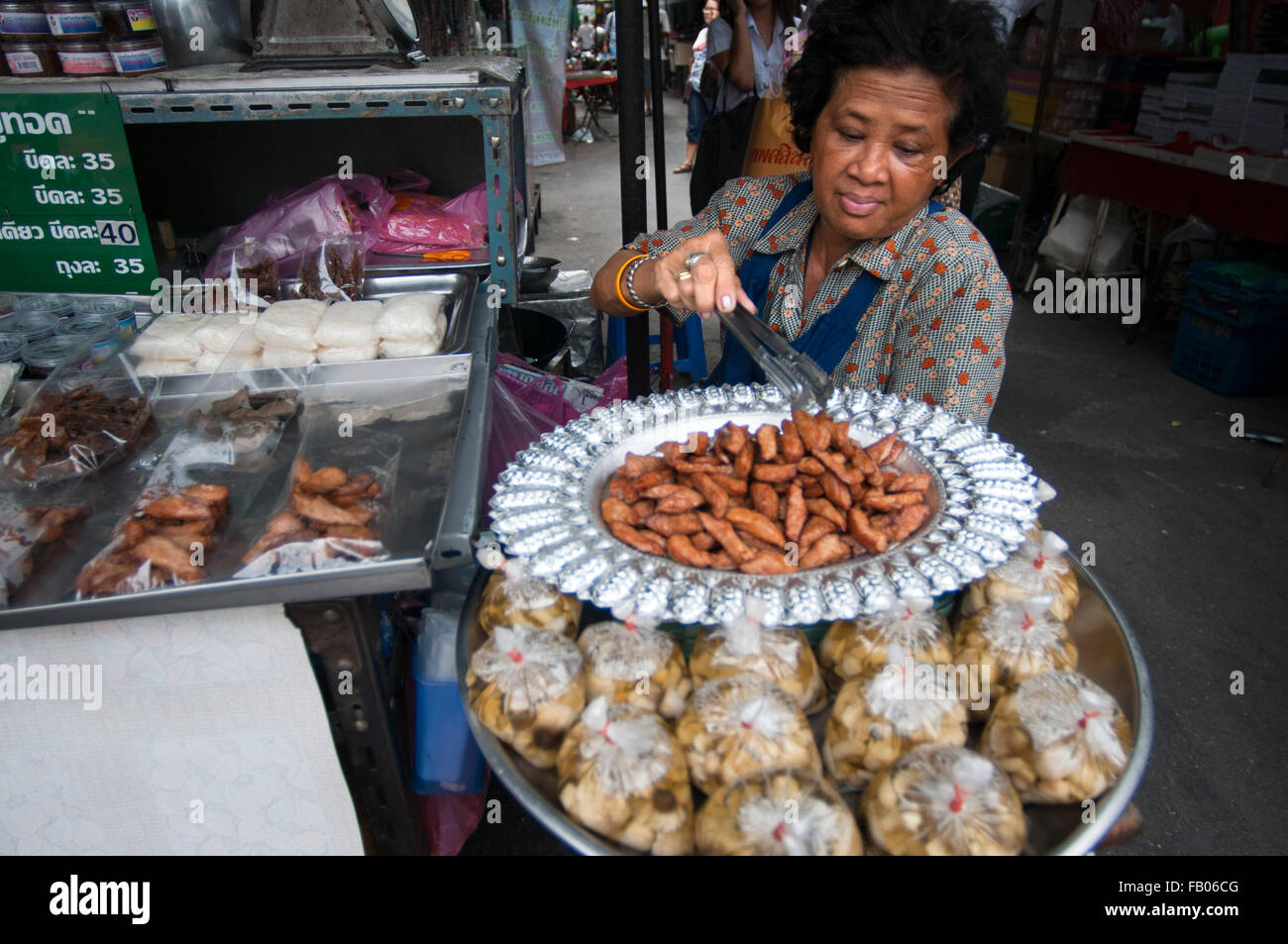 Woman selling pring rolls. Bangkok's Chinatown, Thailand. Market stall and street food being prepared in Chinatown Bangkok, Thai Stock Photo