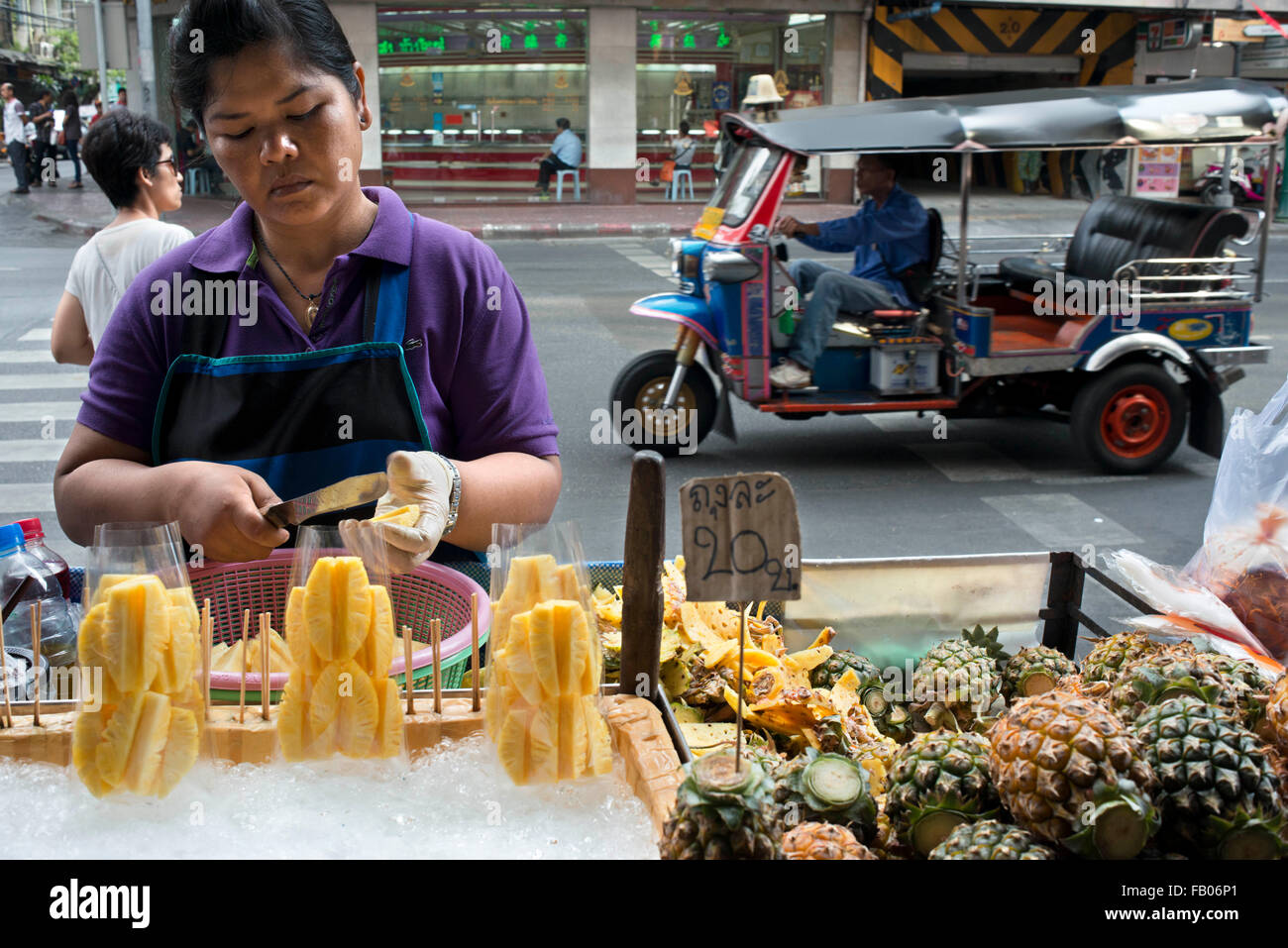 Bangkok fruit and vegetable stall holder surrounded by her produce. A