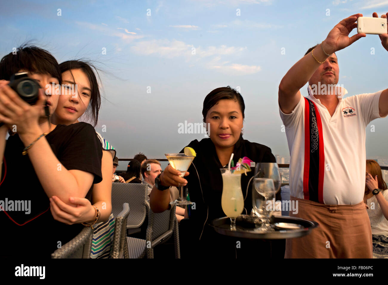 Waitress with cocktails in her hand. Banyan Tree Rooftop Vertigo & Moon Bar, Restaurant, , Bangkok , Thailand. View of the city, Stock Photo