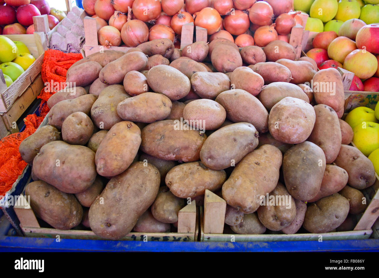 Fresh potatoes on a market stall in an apple box waiting on customers. Stock Photo