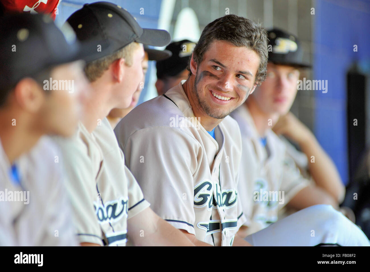 High school teammates share a positive moment in the dugout during a baseball game. USA. Stock Photo