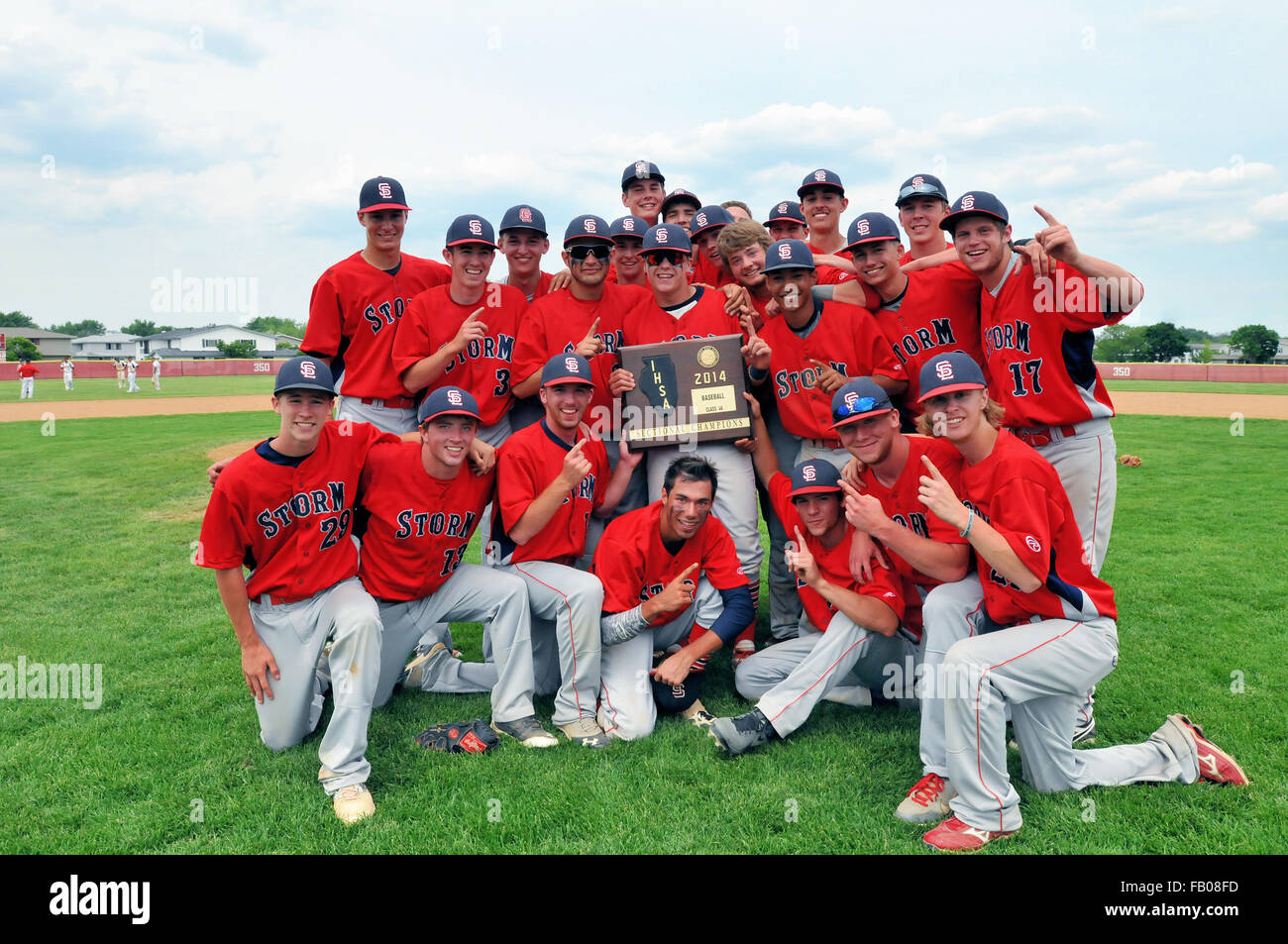 High school baseball team players surround the state sectional title plaque they had just earned on the field. USA. Stock Photo