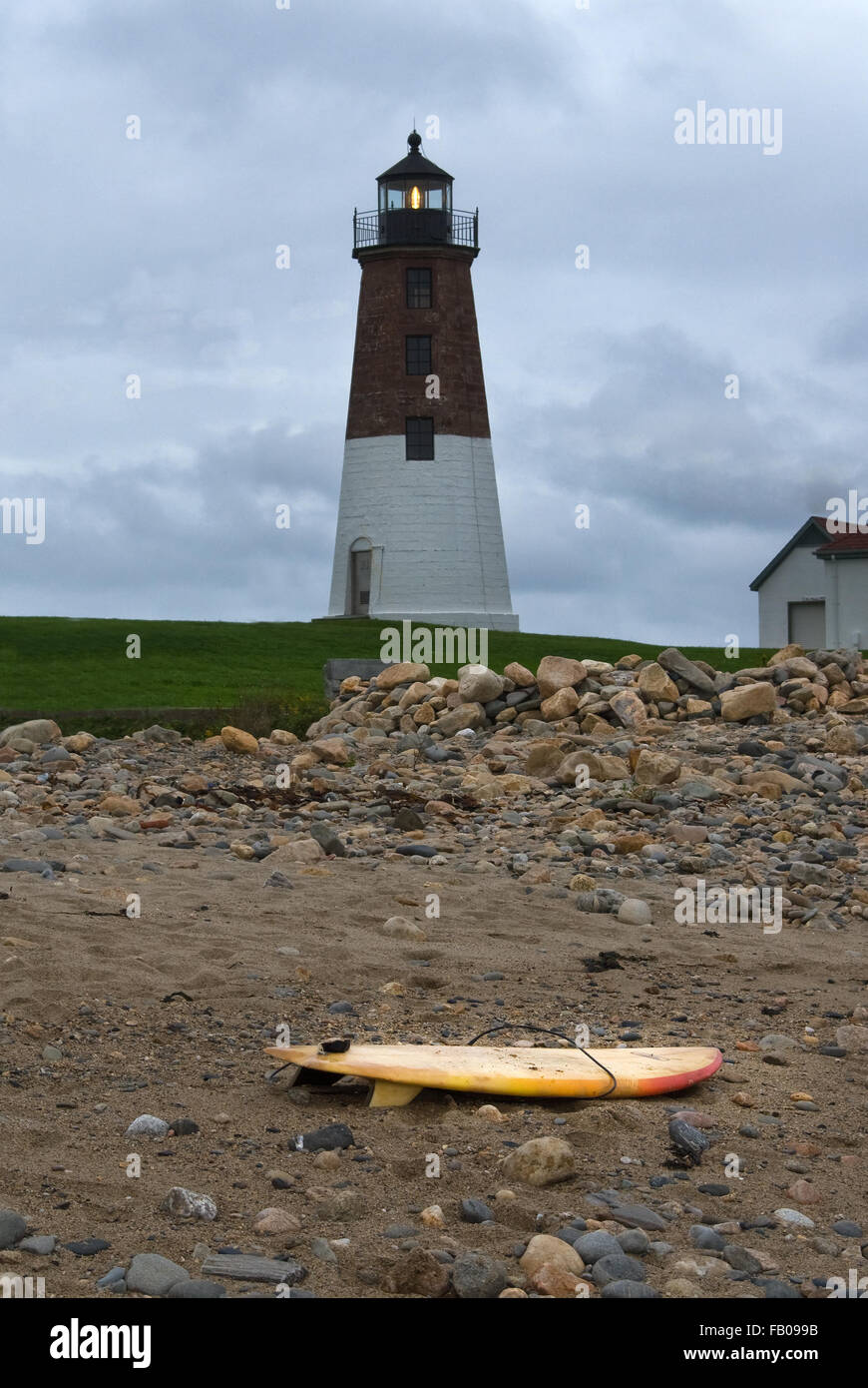 Rescue surfboard placed on beach near Point Judith lighthouse as storm approaches in Rhode Island. Stock Photo