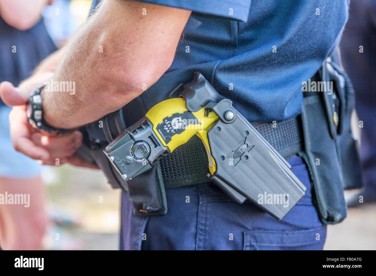 Police officer armed with Taser gun on duty in Brisbane, state capital of Queensland. South Bank Brisbane Australia Stock Photo
