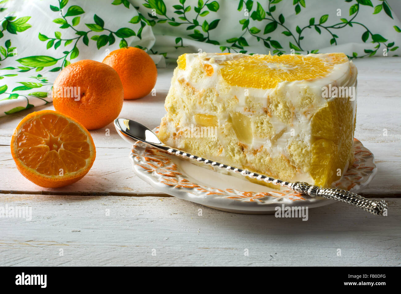 Slice of delicious cold white jelly fruit tart, mousse whipped cream pie yoghurt yogurt souffles cake with orange and tangerine. Stock Photo