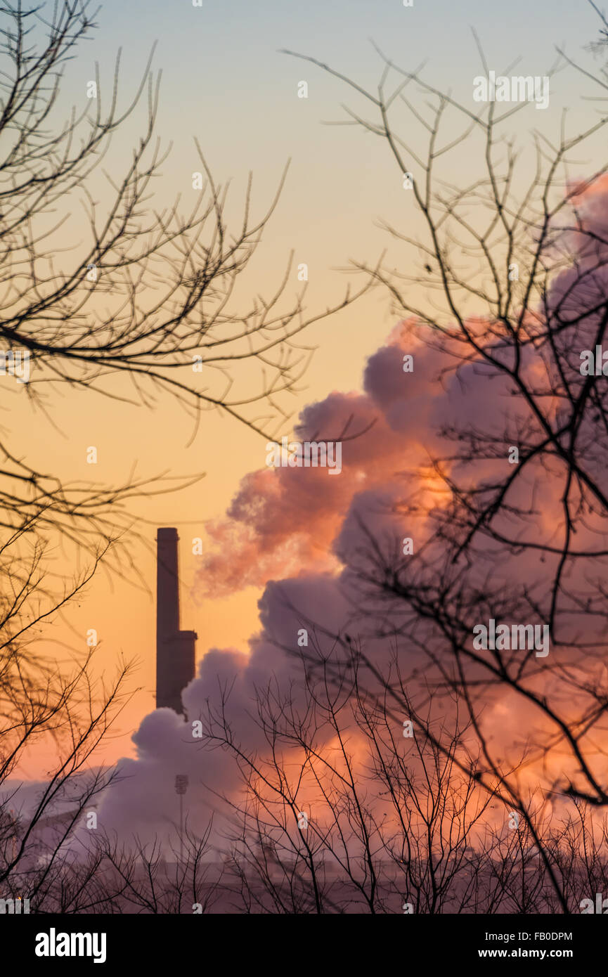 Vivid colors of sunrise paint the sky and plumes of steam from the OG&E Muskogee Power Plant in Fort Gibson, Oklahoma. (USA) Stock Photo