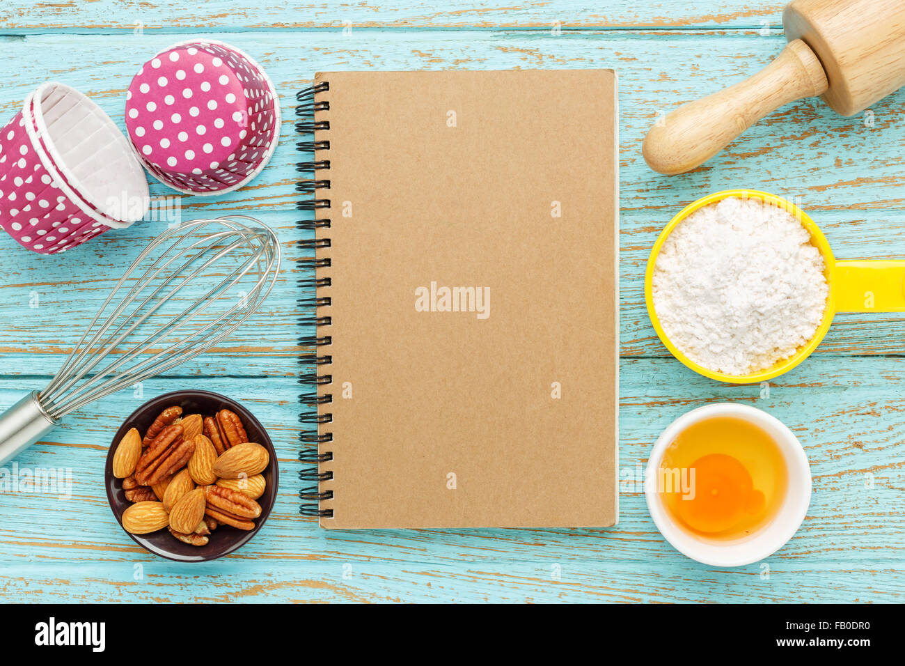 Bake background with kraft notebook and baking ingredients on wood table Stock Photo