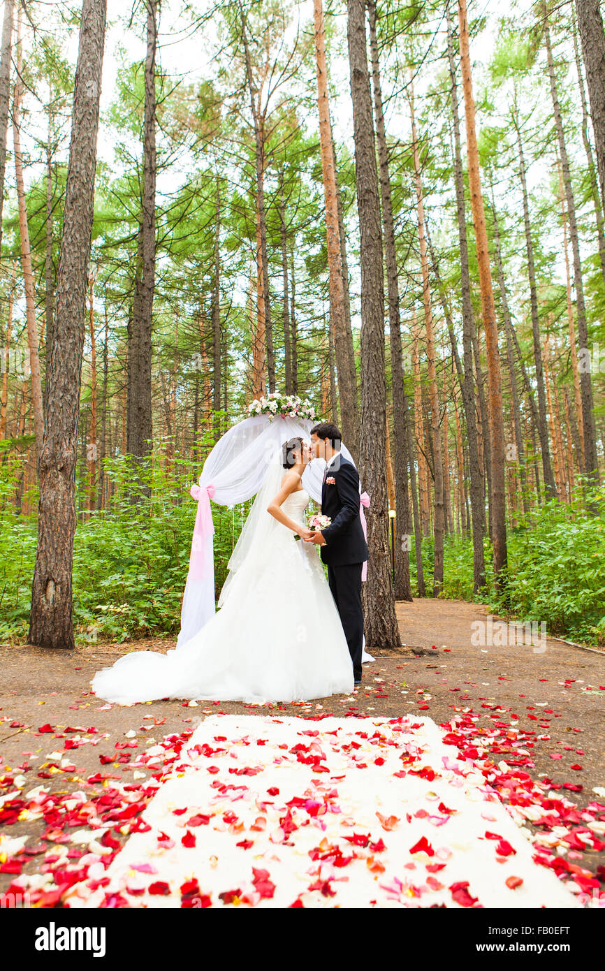 bride and groom kissing near the wedding arch Stock Photo - Alamy