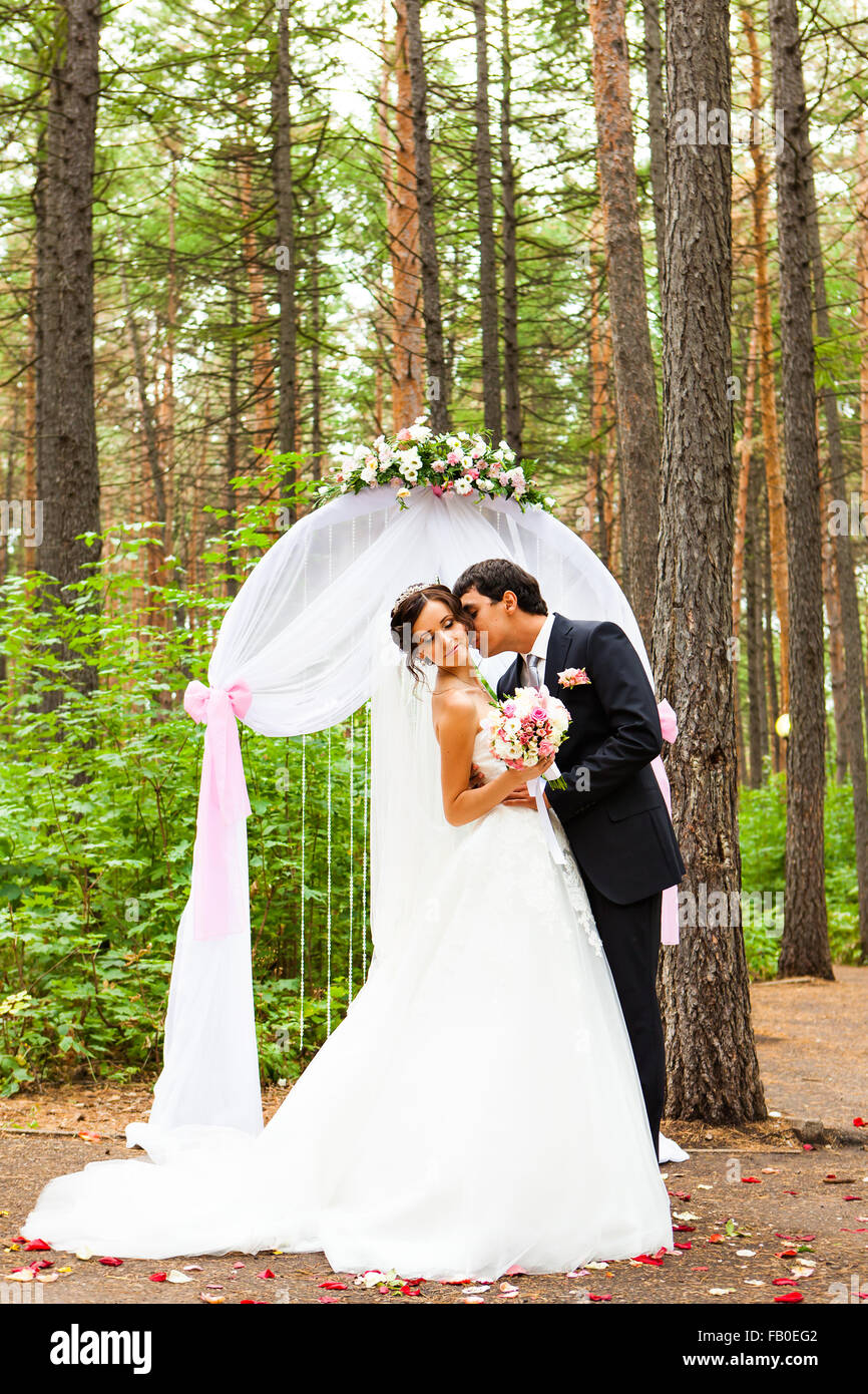 bride and groom kissing near the wedding arch Stock Photo - Alamy