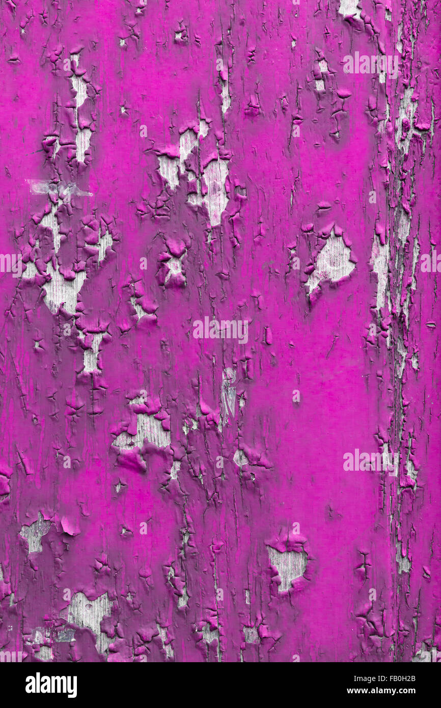 A wooden surface, painted pink with obvious signs of cracking and ...