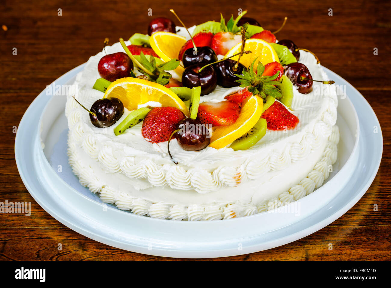 New Year Cake garnished with different kind of fruits Stock Photo