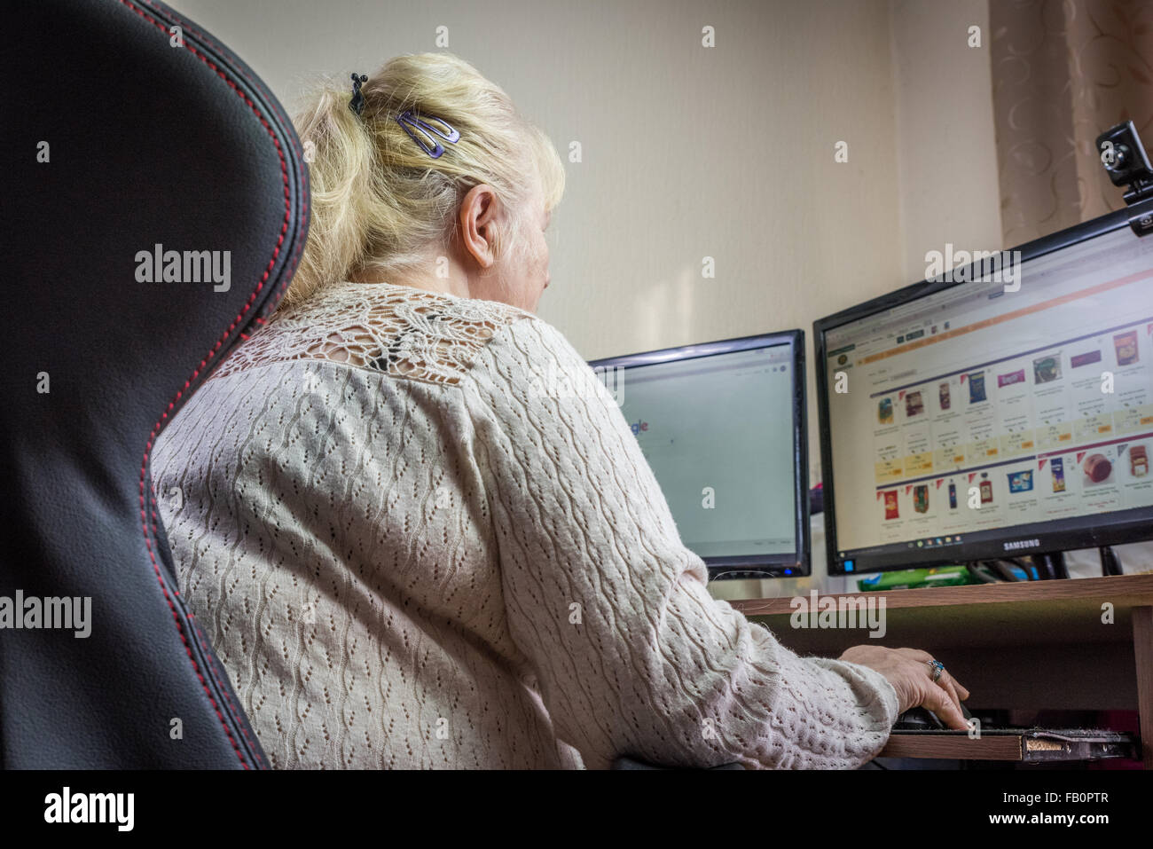An Elderly lady at home ordering her grocery shopping online Stock Photo