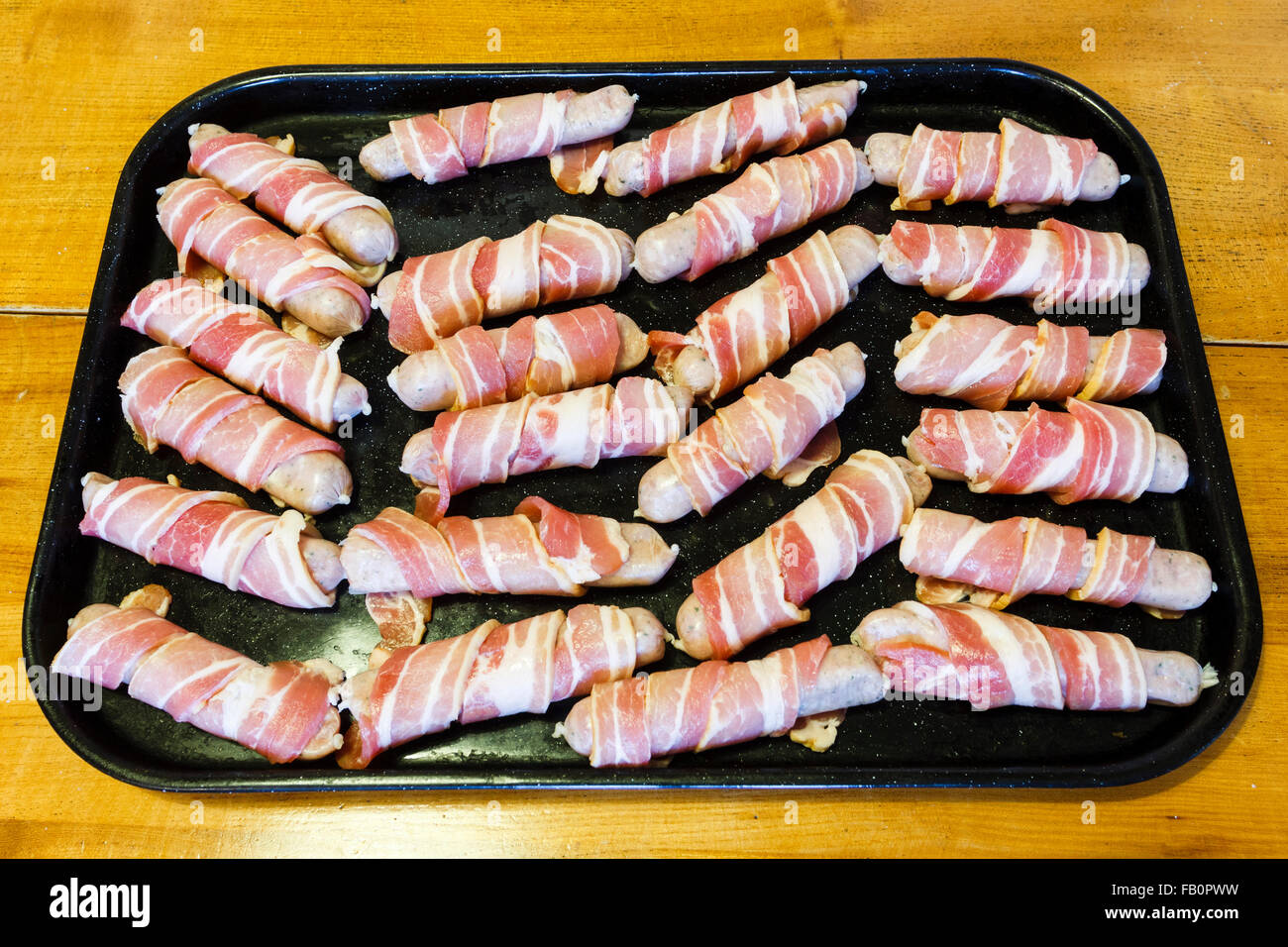 Traditional Christmas food of sausages wrapped in streaky bacon, on a