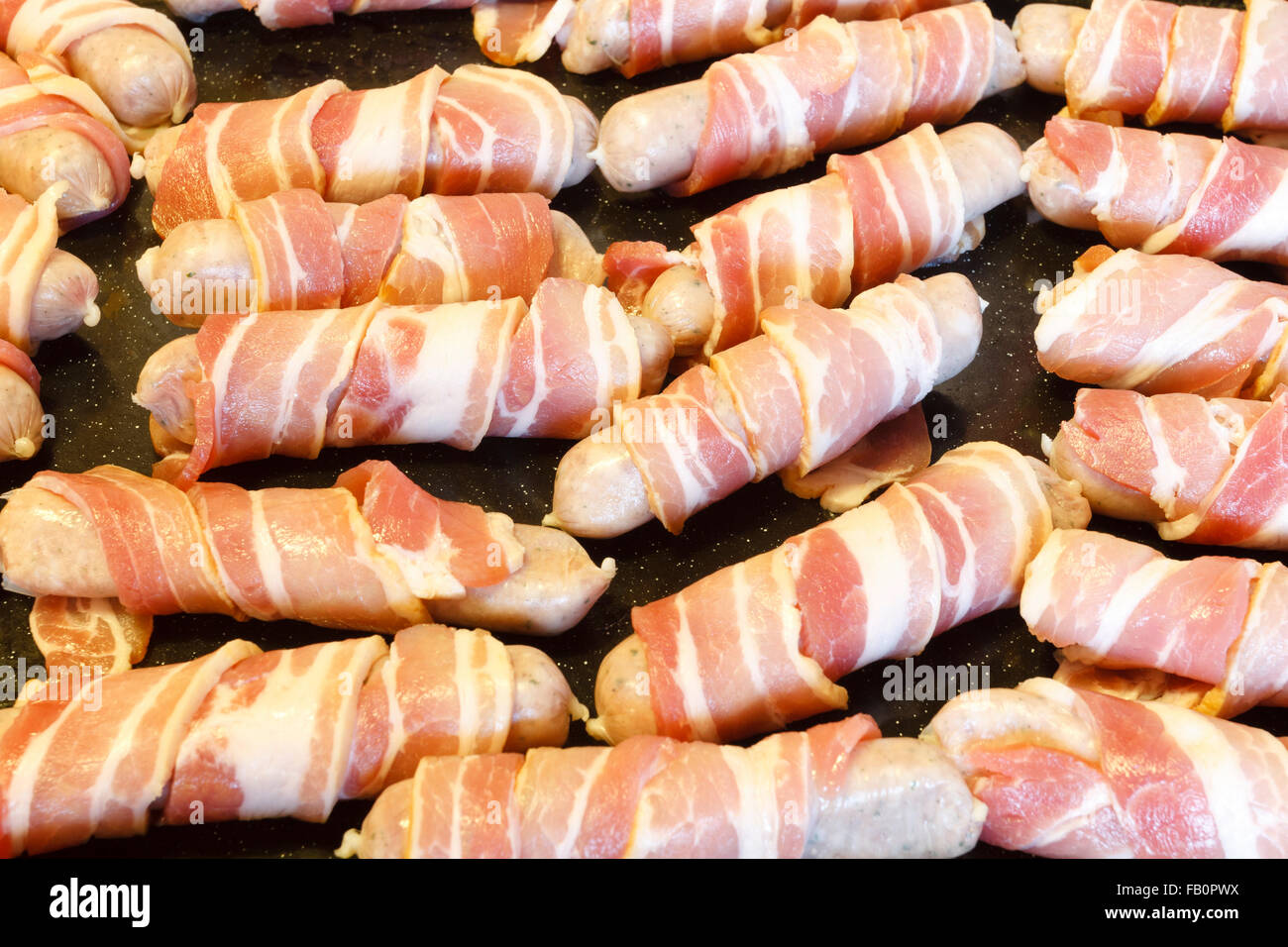 Traditional Christmas food of sausages wrapped in streaky bacon, on a