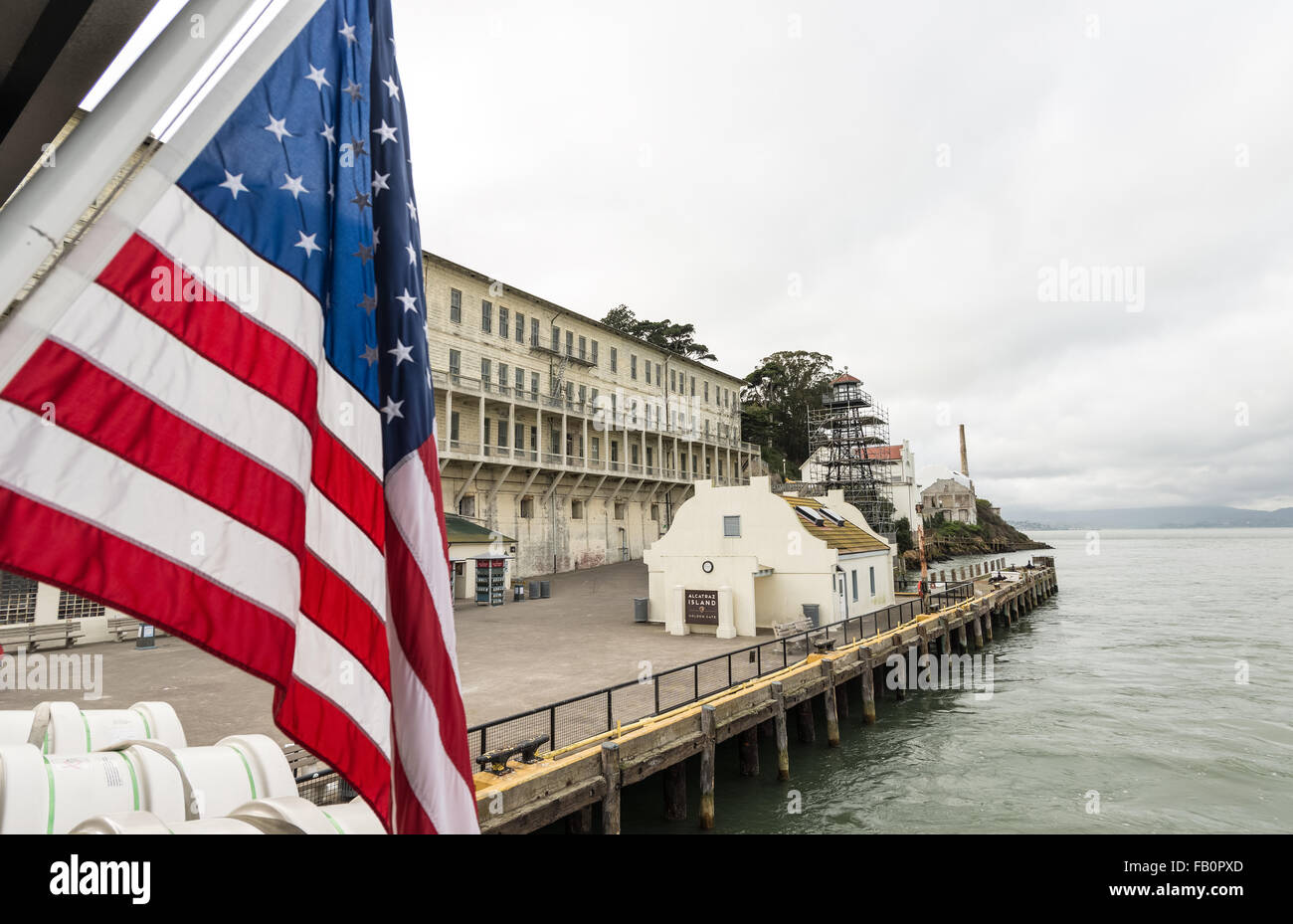 Alcatraz prison and dock with US flag in foreground Stock Photo