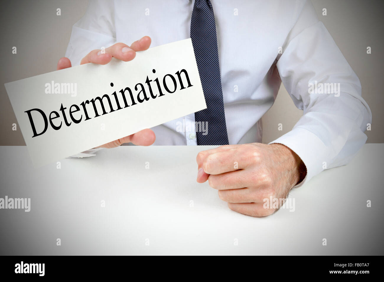 A man holding up a card that reads determination Stock Photo