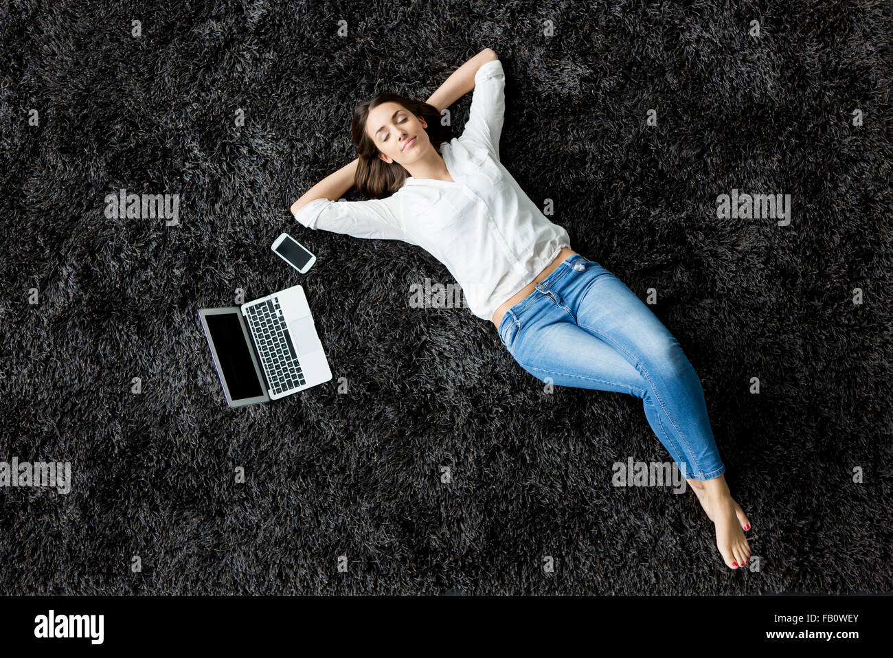 Young woman laying on the carpet Stock Photo