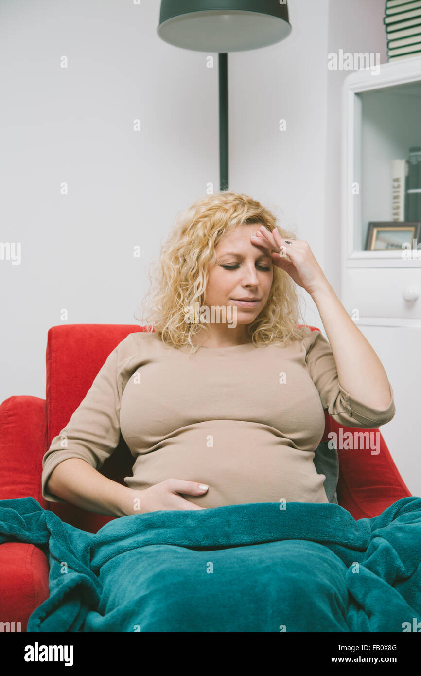 Young pregnant woman sitting in the room Stock Photo