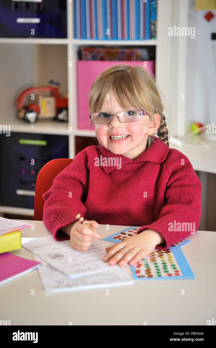 A young girl studying in a home enviroment completing her homework. Stock Photo