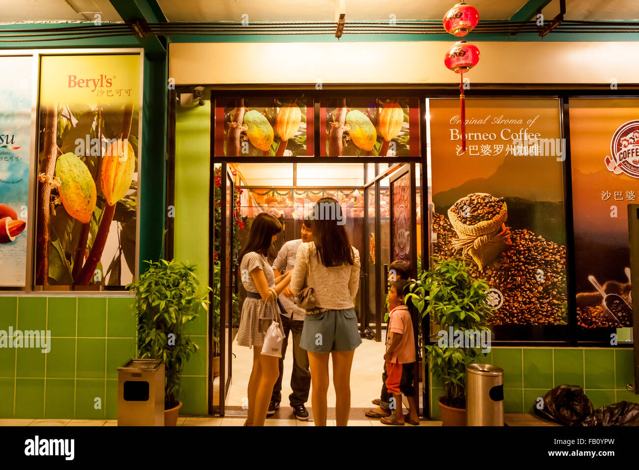 People standing at the entrance of a coffee bean shop in Kota Kinabalu