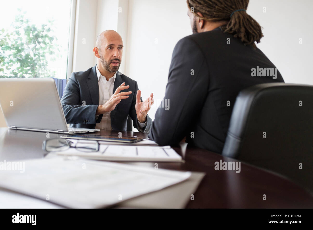 Two businessmen having discussion at desk in office Stock Photo Alamy