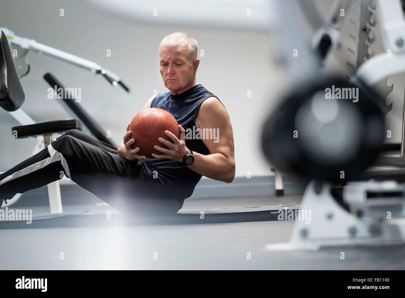 Man in health club exercising with ball Stock Photo