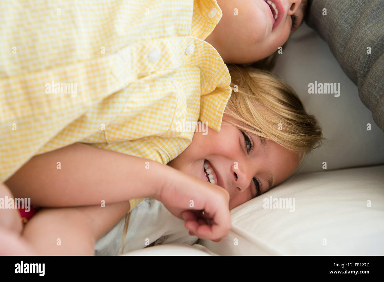 Boy (4-5) and girl (6-7) playing on sofa Stock Photo