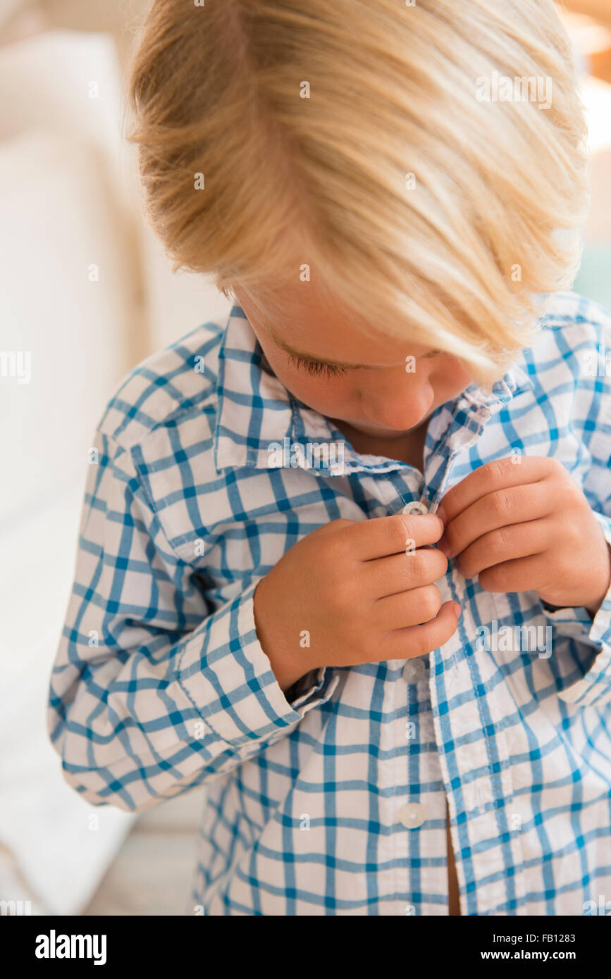 Boy (45) buttoning shirt Stock Photo Alamy