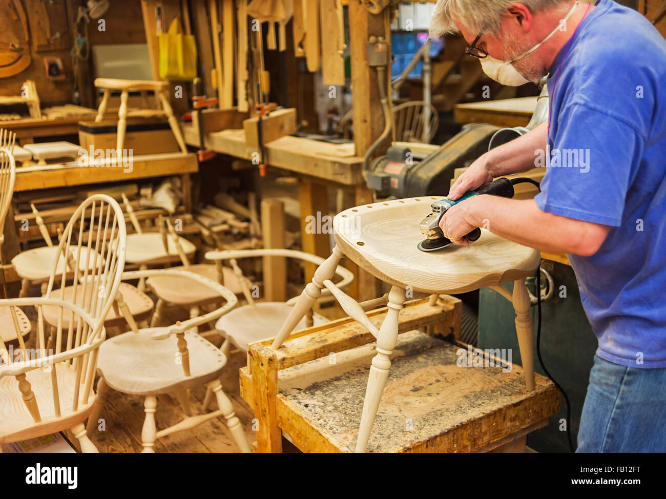 Carpenter polishing chair with sander Stock Photo Alamy