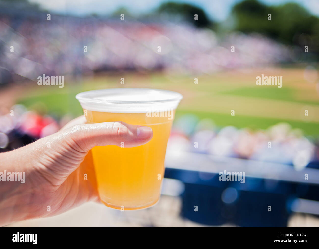 Close-up of hand holding beer at stadium Stock Photo
