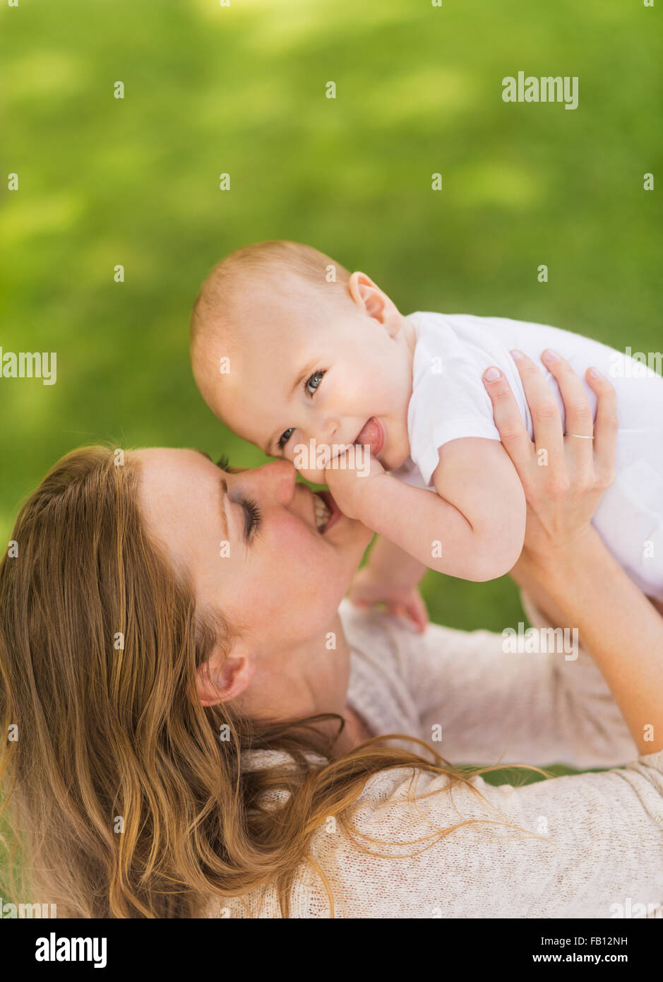 Mother holding up baby boy (6-11 months) Stock Photo