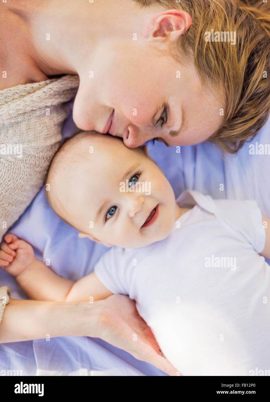 Mother lying down with baby boy (6-11 months) Stock Photo