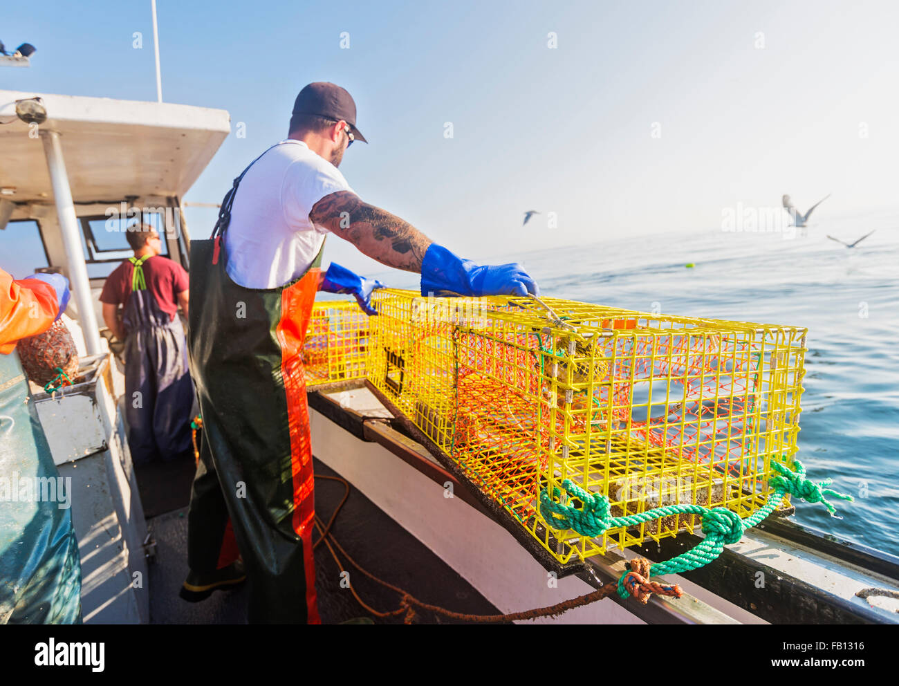 Three fishermen working on boat Stock Photo Alamy