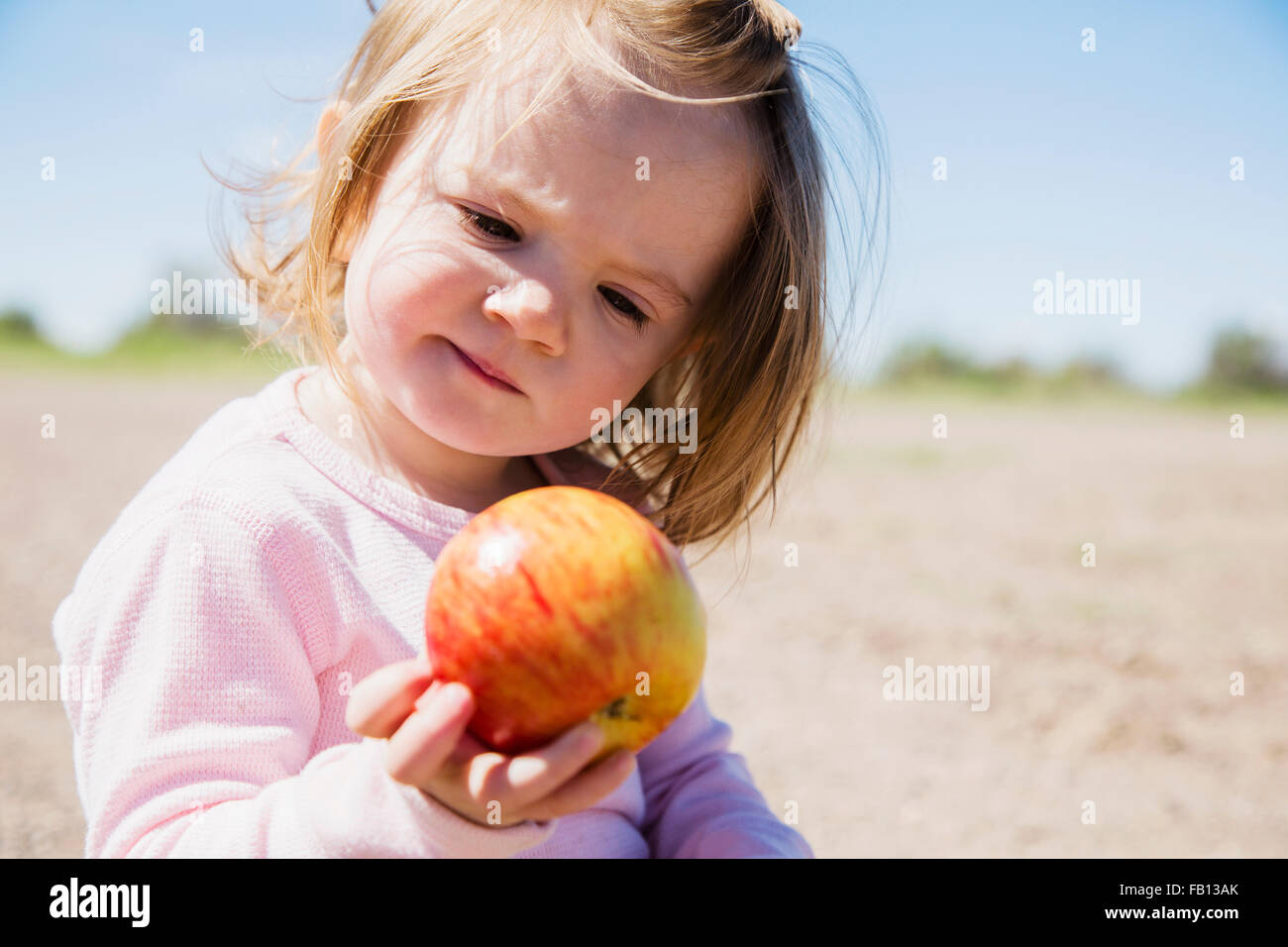 Portrait of girl (2-3) holding apple Stock Photo