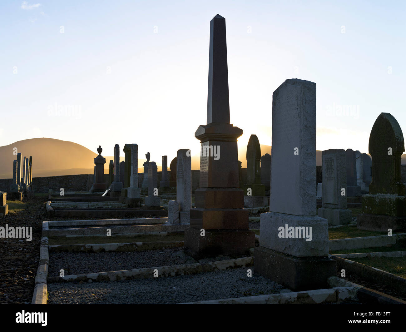 dh Stromness Cemetery WARBETH ORKNEY Grave stone sunset cemetery gravestones gravestone silhouette uk winter Stock Photo