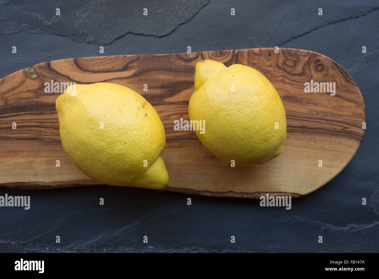 Two lemons on wood board Stock Photo