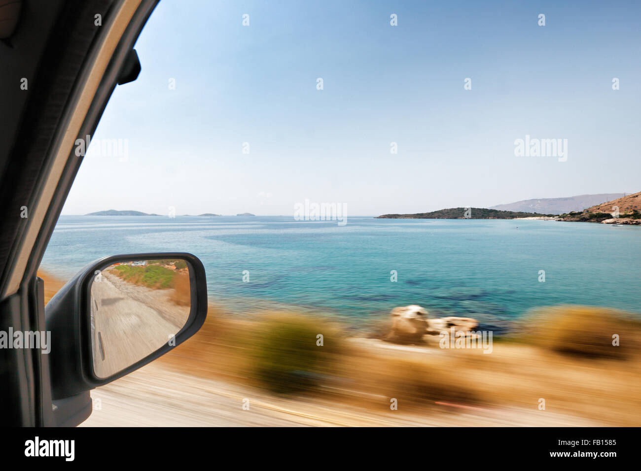 The view through the window from the perspective of the passenger in a moving car traveling around Andros, Greece Stock Photo