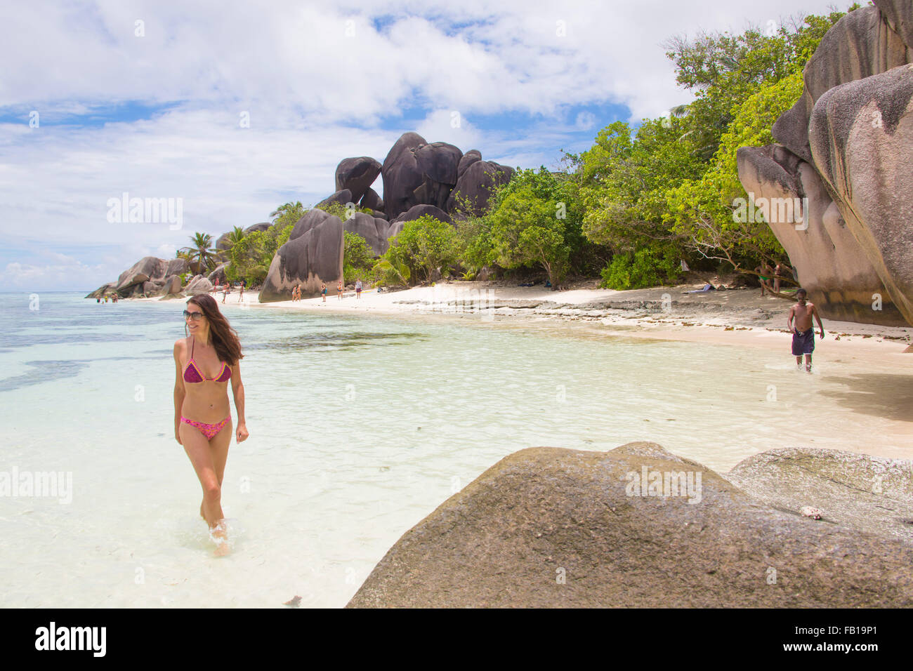 Beautiful woman posing on the famous Source D´Argent white sandy beach with palmtrees on September 27, 2015 in La Passe, La Digu Stock Photo