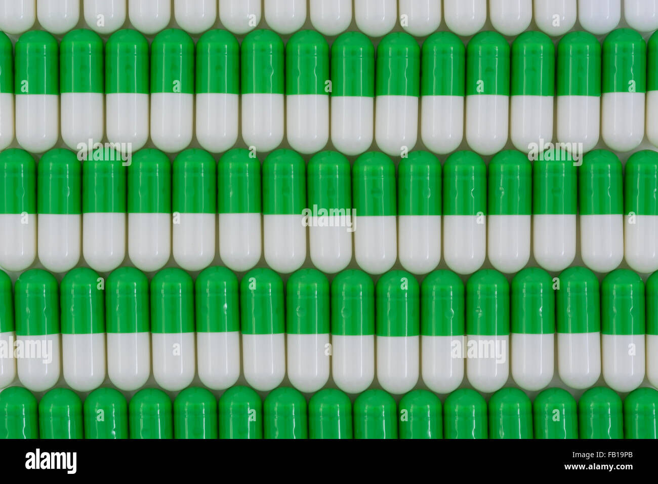 Close-up of pills - capsule form made of gelatin. Green / White pills. Metaphor taking on American drug companies over high drug prices, drug trials. Stock Photo