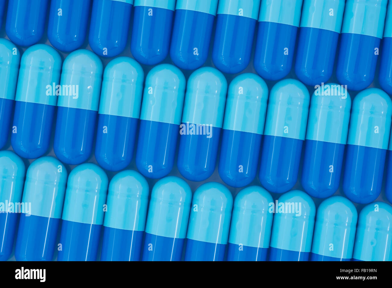 Close-up of pills - capsule form made of gelatin. Blue pills - possible metaphor for NHS / National Health Service. Taking on US drug companies. Stock Photo
