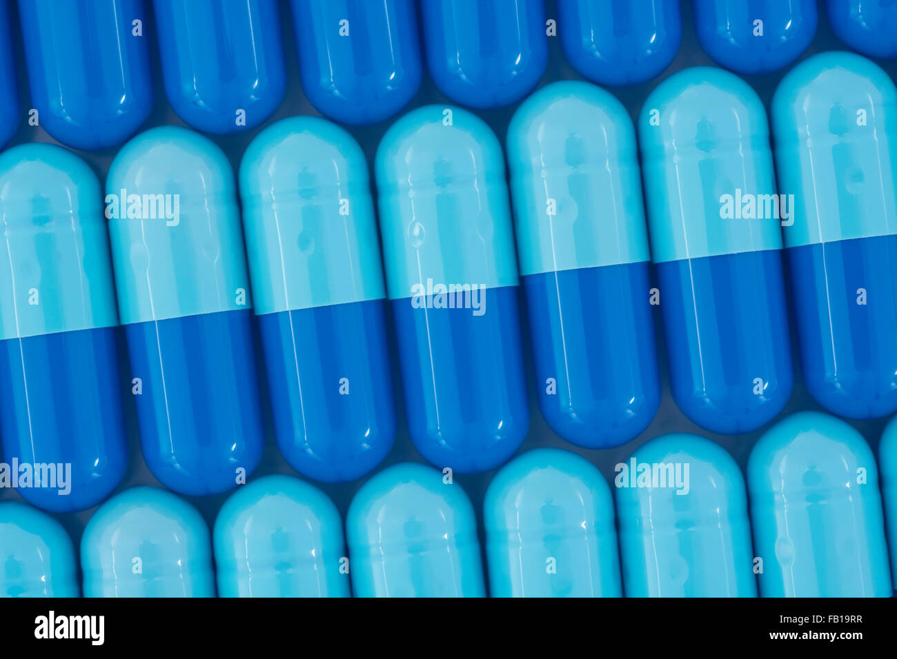 Close-up of pills - capsule form made of gelatin. Blue pills - possible metaphor for NHS / National Health Service. Taking on US drug companies. Stock Photo