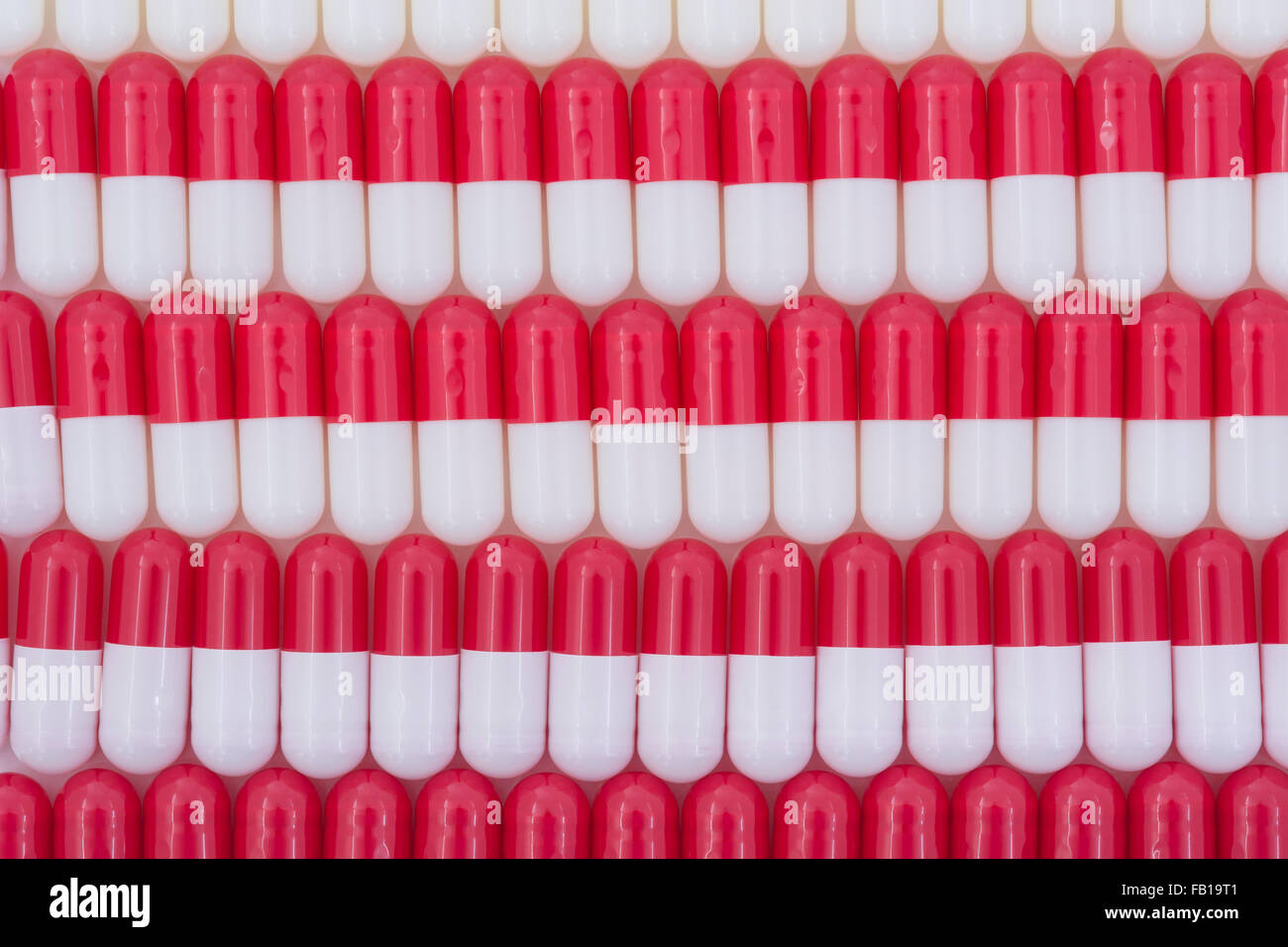 Close-up of pills - capsule form made of gelatin. Red / White pills. Metaphor taking on American drug companies over high drug prices, drug trials. Stock Photo