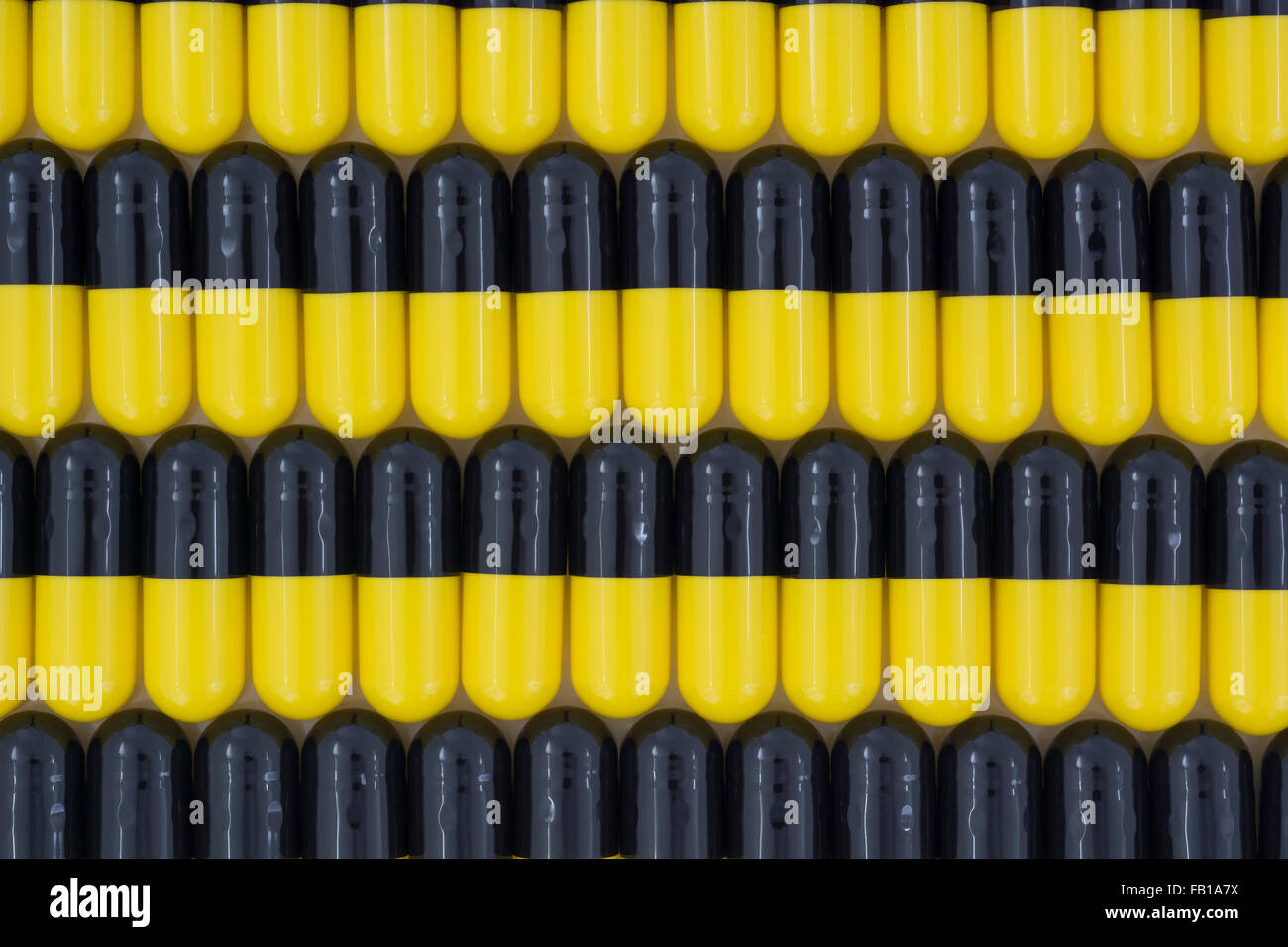 Close-up of pills - capsule form made of gelatin. Yellow / Black pills. Metaphor Trump taking on American drug companies over high drug prices. Stock Photo