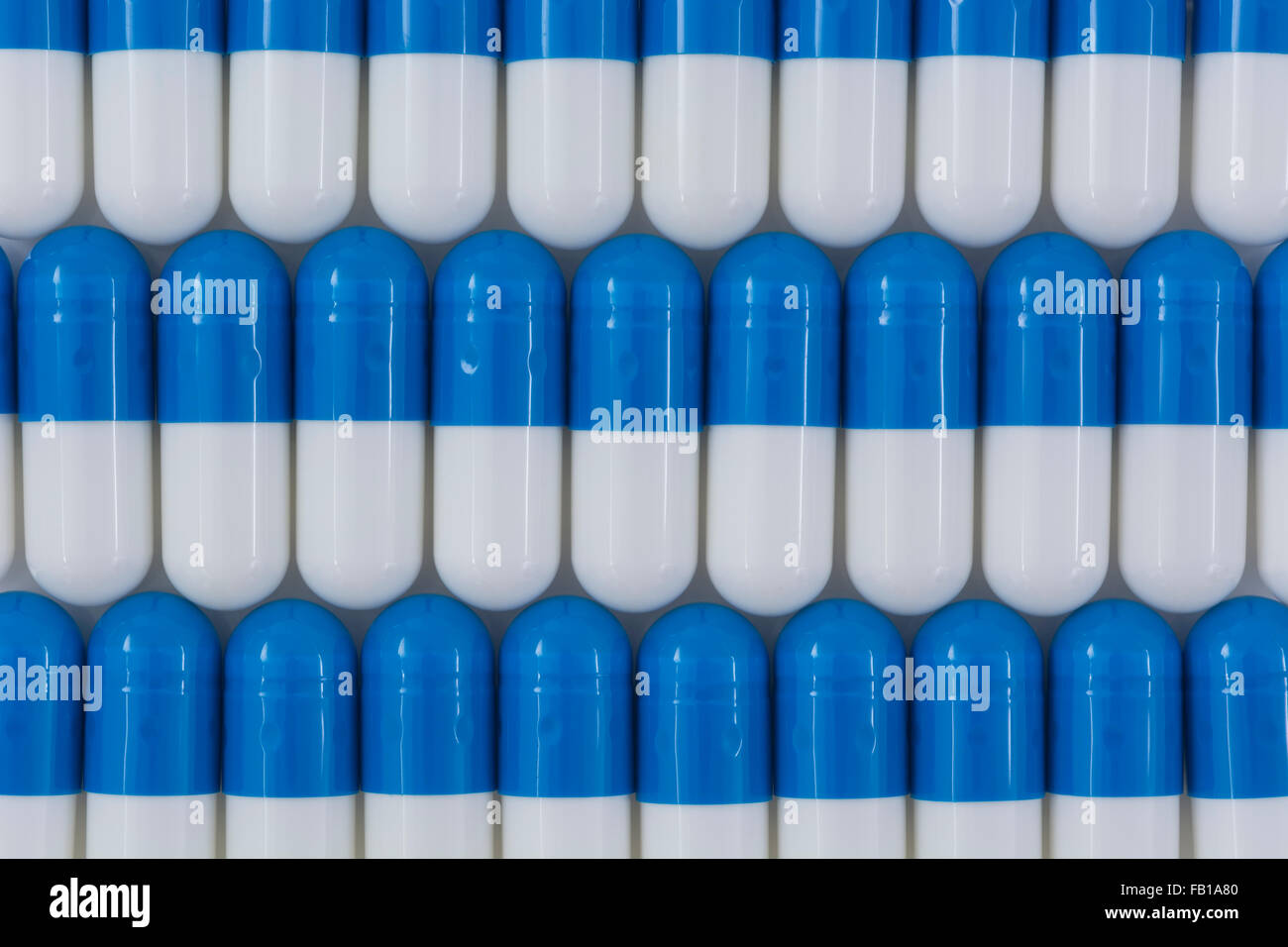 Close-up of blue and white pills - capsule form made of gelatin. Blue / White pills. Metaphor taking on American drug companies over high drug prices, Stock Photo