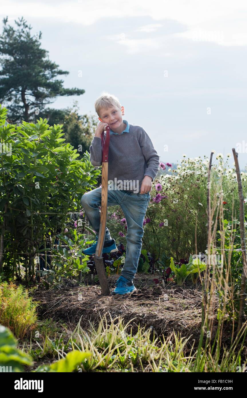 Portrait of boy digging in organic garden Stock Photo